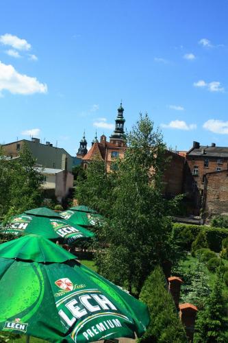 a group of green umbrellas sitting next to a building at W Starej Kamienicy in Gniezno