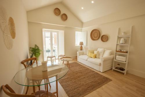 uma sala de estar com uma mesa de vidro e um sofá em Ana´s House em Setúbal