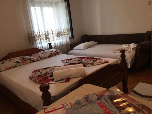 two twin beds in a room with a window at Guest house Naser in Ulcinj