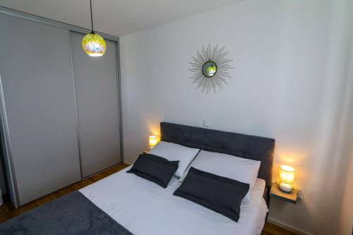 1 dormitorio con 1 cama blanca y 2 almohadas negras en Luce Gold Apartment, en Zadar