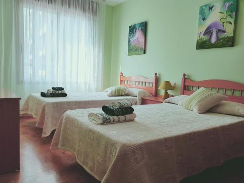 a bedroom with three beds with towels on them at Piso amplio en el centro de Vilagarcía de Arousa in Vilagarcia de Arousa