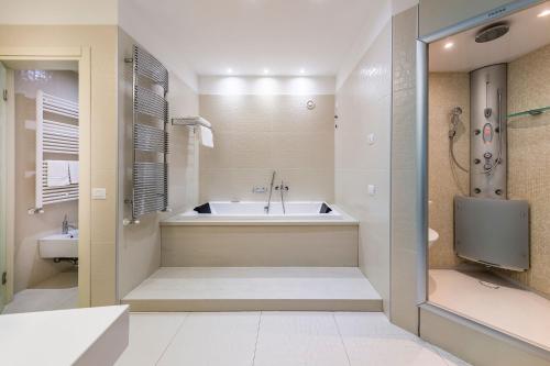 a large bathroom with a tub and a shower at Base Hotel in Noventa di Piave