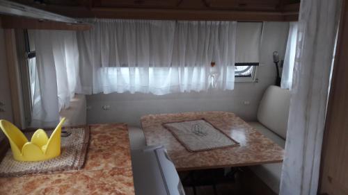 グラネッリにあるcamping Venereのテーブルと窓が備わる小さな客室です。