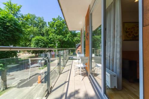 a balcony with glass railing and a view of a street at Daukanto Sun Apartment in Palanga