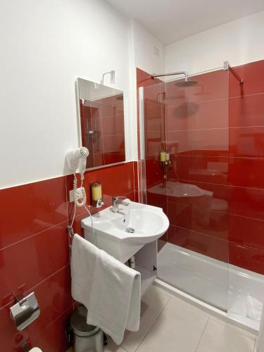 a red bathroom with a sink and a shower at Roma Resort Colosseum in Rome