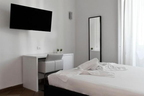 a white bedroom with a bed and a desk at Roma Resort Colosseum in Rome