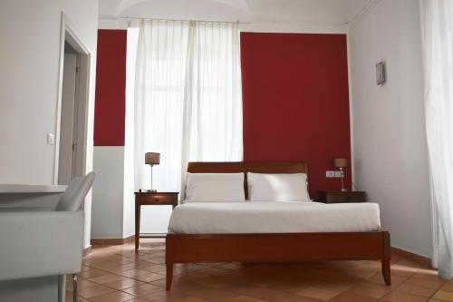 a bedroom with a bed and a red wall at Roma Resort Colosseum in Rome