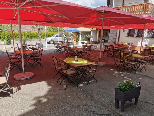 a group of tables and chairs with red umbrellas at Alemannenhof Hotel Engel in Rickenbach