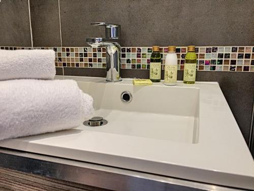 - un lavabo dans la salle de bains avec 2 bouteilles de vin dans l'établissement Nestor&Jeeves - HOLIDAY VIBES - Very close sea - Free parking, à Nice