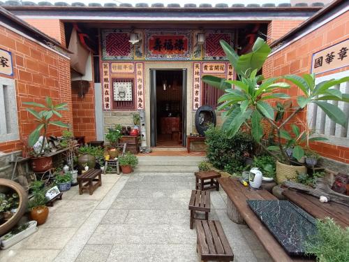 a courtyard of a building with benches and plants at 彼岸古厝民宿-包棟優先--Biiann B&B in Jinning
