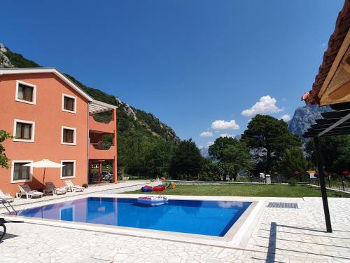 une piscine en face d'un bâtiment dans l'établissement Milas Trojica Kotor, à Kotor