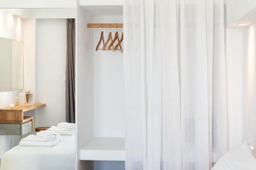 クリシ・アクティにあるGolden Beach Hotelの白いカーテンが備わる客室のベッド2台