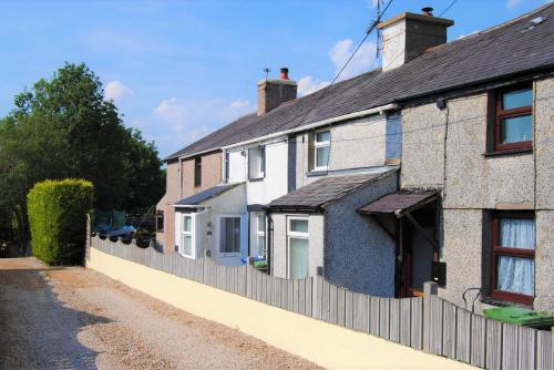 uma fila de casas com uma cerca em Snowdon Cottage 2 em Llanrug