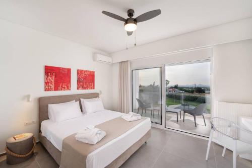 a white bedroom with a bed and a balcony at Melia Villa Kos with Heated Pool in Kos Town