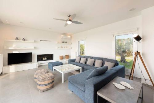 a living room with a blue couch and a table at Melia Villa Kos with Heated Pool in Kos Town