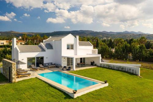 a white house with a swimming pool in the yard at Melia Villa Kos with Heated Pool in Kos Town