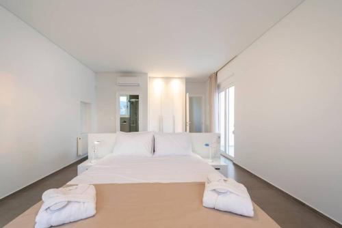 a bedroom with a large bed with two towels on it at Melia Villa Kos with Heated Pool in Kos Town