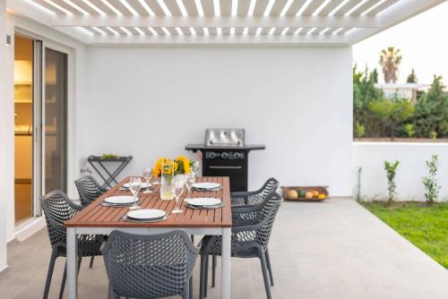 a wooden table and chairs on a patio at Melia Villa Kos with Heated Pool in Kos Town