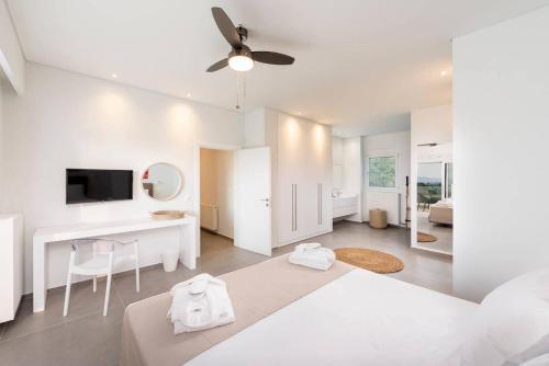 a white bedroom with a bed and a desk at Melia Villa Kos with Heated Pool in Kos Town