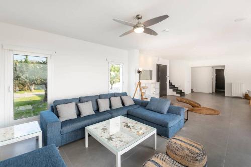 a living room with a blue couch and a table at Melia Villa Kos with Heated Pool in Kos Town
