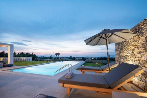 a villa with a swimming pool and an umbrella at Melia Villa Kos with Heated Pool in Kos Town