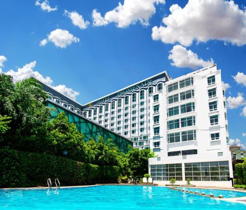 ein Hotel mit einem großen Pool vor einem Gebäude in der Unterkunft Promenade Hotel Kota Kinabalu in Kota Kinabalu