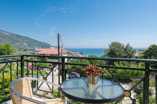 a table with a vase of flowers on a balcony at Dimitreli Eleni Studios in Koinyra