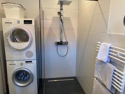 uma casa de banho com uma máquina de lavar roupa e uma máquina de lavar roupa. em Freimuth`s Hof em Südbrookmerland