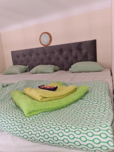 ein Bett mit einem grünen Handtuch und einer Fernbedienung darauf in der Unterkunft AMBER APARTAMENt #10 in Krakau
