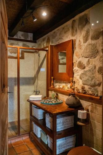 a stone bathroom with a sink and a shower at LA CASA DEL BUHO in Santa María la Real de Nieva
