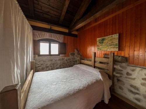 Santa María la Real de NievaにあるLA CASA DEL BUHOの木製の部屋にベッド1台が備わるベッドルーム1室があります。