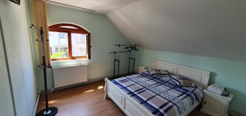 a bedroom with a bed and a window at Vila Vasile in Mamaia Sat/Năvodari