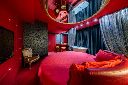 um quarto vermelho com uma cama grande e um espelho em Base Hotel em Noventa di Piave