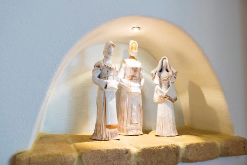 two figurines of two women sitting on a ledge at Sa Branda Costa Country Alghero in Santa Maria la Palma