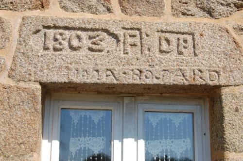 a stone building with a sign above a window at Le Pont St Michel in Maen Roch