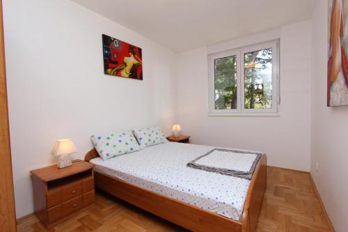 ein kleines Schlafzimmer mit einem Bett und einem Fenster in der Unterkunft Apartment Nautica in Novigrad Istria