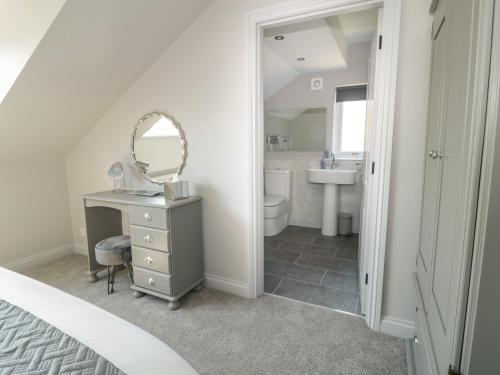 a bedroom with a vanity and a mirror and a sink at Garth End in Kirkby Thore