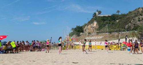 a group of people standing on a beach at The Hollidays Apartment in Calella