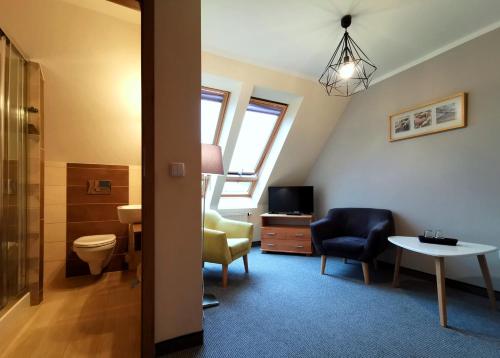 a bathroom with a toilet and a chair and a table at Galicówka in Poronin