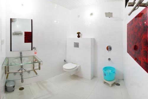 a white bathroom with a toilet and a sink at Exquisite Luxurious Presidential Stay- Pure Veg in Dalhousie
