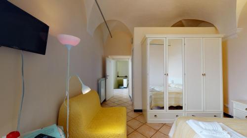 een slaapkamer met een bed en een gele stoel bij B&B La Canonica - Svegliarsi a Verezzi in Borgio Verezzi