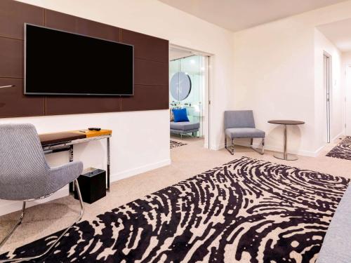 a living room filled with furniture and a television at Novotel Brisbane South Bank in Brisbane