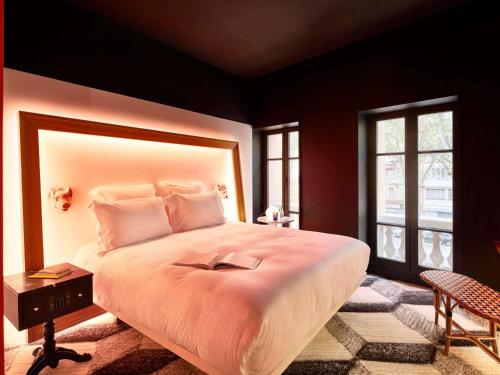 Un dormitorio con una gran cama blanca y una ventana en Mama Shelter Toulouse en Toulouse