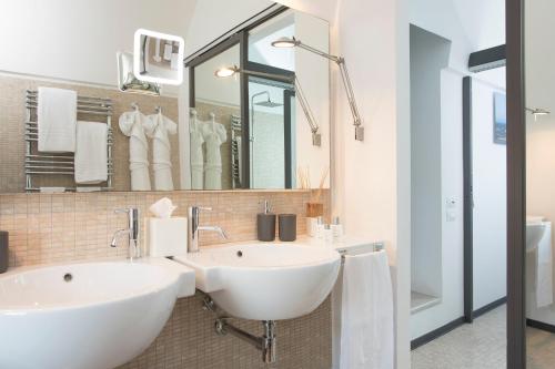 ein Badezimmer mit zwei Waschbecken und einem großen Spiegel in der Unterkunft Bartago Luxury House in Ostuni