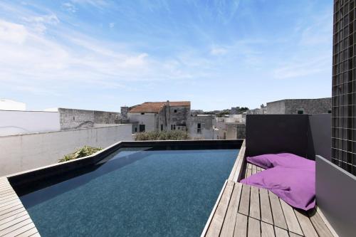 an outdoor swimming pool on the roof of a building at Bartago Luxury House in Ostuni