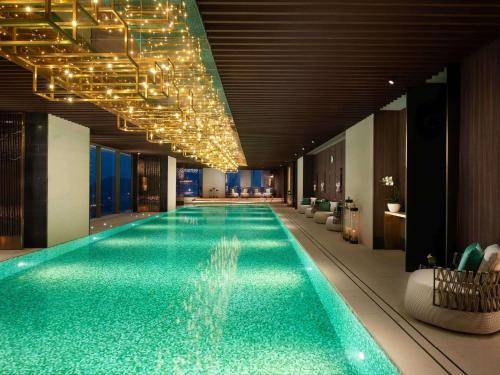 a large swimming pool in a hotel with lights at Raffles Shenzhen, Enjoy the daily happy hour in Long Bar, complimentary mini bar and welcome amenities in Shenzhen