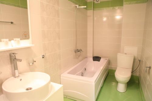 a bathroom with a sink and a toilet and a bath tub at Meatsa Hotel in Kŭrdzhali