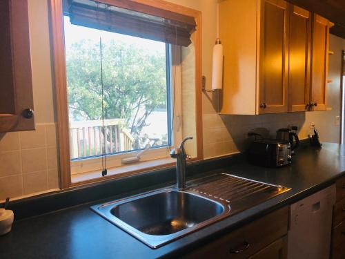 a kitchen with a sink and a window with a view at Midnight Sun Vacation Home in Whitehorse