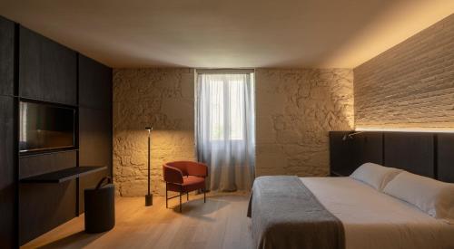 a hotel room with a bed and a chair at Casa Grande Hotel in Grañón