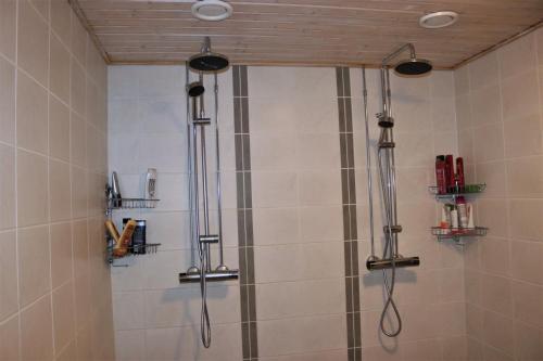 a shower with two shower heads in a bathroom at Kipinä Lomat - Majatalo Kipinä in Sotkamo